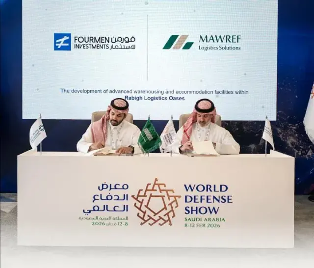 Fourmen Investments and Mawref Logistics Solutions signing a strategic cooperation agreement at the World Defense Show, beneath a screen reading “The development of advanced warehousing and accommodation facilities within Rabigh Logistics Oases”.